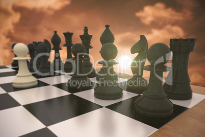 Composite image of black chess pieces on board with white pawn