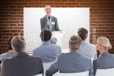 Composite image of businesswoman doing speech during meeting