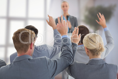 Composite image of business team raising hands during conference