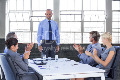 Composite image of business people applauding during meeting