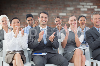 Composite image of business people applauding during meeting