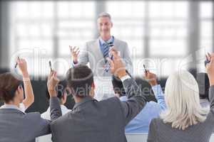 Composite image of business people raising their arms during meeting
