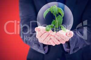 Composite image of scientist holding basil plant