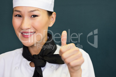 Composite image of portrait of smiling female cook gesturing thumbs up
