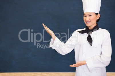Composite image of portrait of a smiling female cook in kitchen