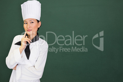 Composite image of portrait of thoughtful female cook in kitchen