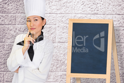 Composite image of portrait of thoughtful female cook in kitchen