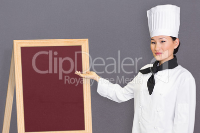 Composite image of confident female cook in the kitchen