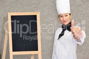 Composite image of smiling female cook gesturing thumbs up in kitchen