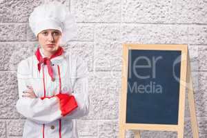 Composite image of pretty chef standing with arms crossed