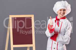 Composite image of pretty chef showing thumbs up