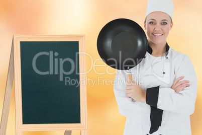 Composite image of female chef with arms crossed holds frying pan