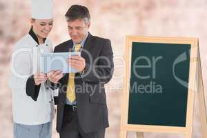 Composite image of a cook showing a tablet to a businessman