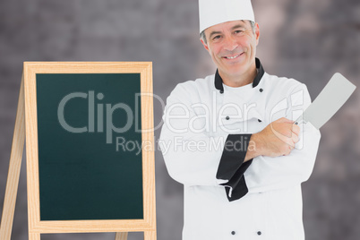 Composite image of man in chef uniform holding meat cleaver
