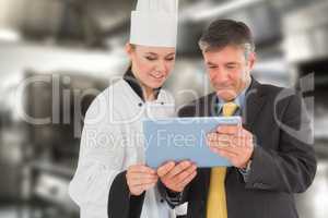 Composite image of businessman and female chef using digital tablet