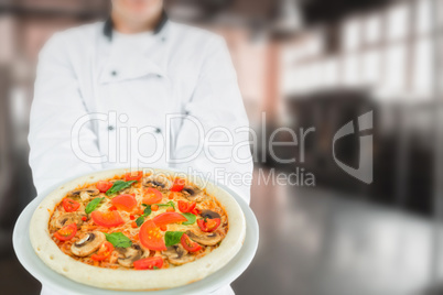 Composite image of chef holding delicious pizza