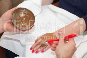 Therapist applying nourishing mask on woman's hand