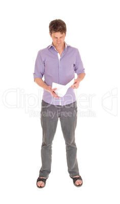 Man standing reading some papers.