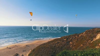 Paragliders Fly Over the Ocean Beach, sunny day