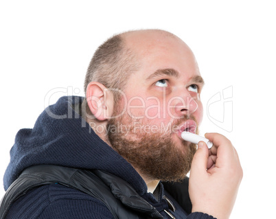 Bald Bearded Fat Man Uses a Protective Lipstick