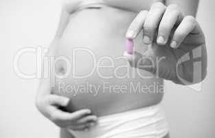 Vitamin pill in the hands of a pregnant woman