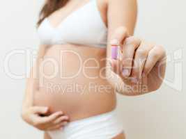Vitamin pill in the hands of a pregnant woman