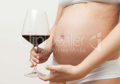 Pregnant woman with glass of red wine