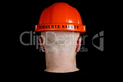 Construction worker in hard hat with an inscription observe safe