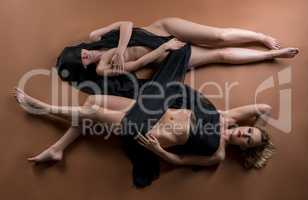 Top view of two nude women posing with fabric