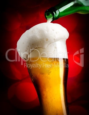 Pouring beer on red background