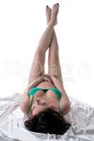 Pregnant woman posing lying while raised high legs