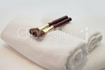 Wellness concept with white rolled towels and treatment brushes