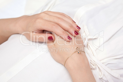 Woman's hands elegantly resting on her belly while relaxing