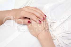 Woman's hands elegantly resting on her belly while relaxing