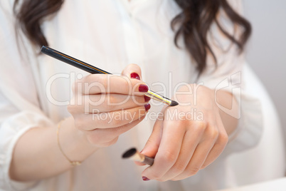 Makeup artist trying new makeup brushes on her hand