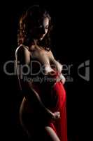 Beautiful naked pregnant woman posing in dark