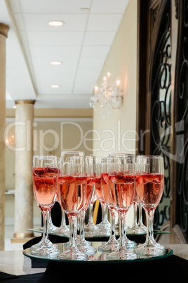 Festive champagne flutes filled with sparkling wine and floating strawberries romantic twinkling party lights