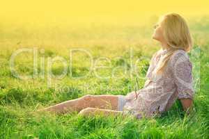 Girl is relaxing on green field