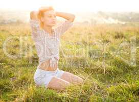 Girl is relaxing on green field