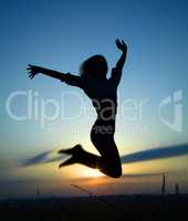 Silhouette of a girl jumping over sunset