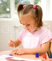 Little girl is play with paints