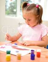 Little girl is play with paints