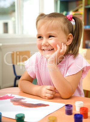 Little girl is play with paints