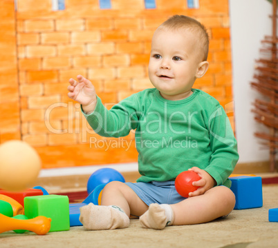 Little boy is playing with toys in preschool
