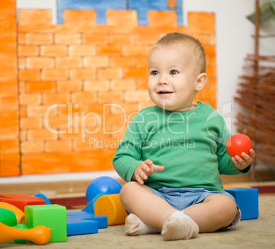 Little boy is playing with toys in preschool