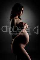 Side view of pregnant woman posing nude