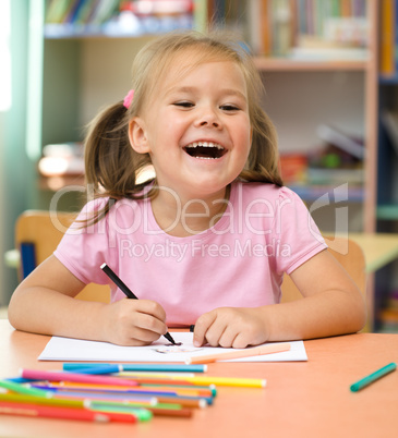 Little girl is drawing with felt-tip pen