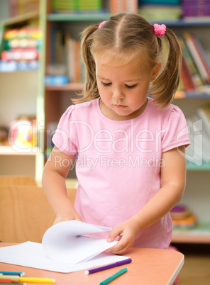 Little girl is drawing with felt-tip pen