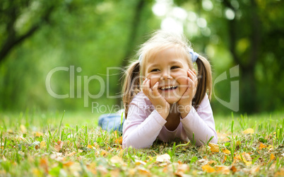 Little girl is playing in autumn park