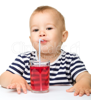Cute little boy is drinking red juice